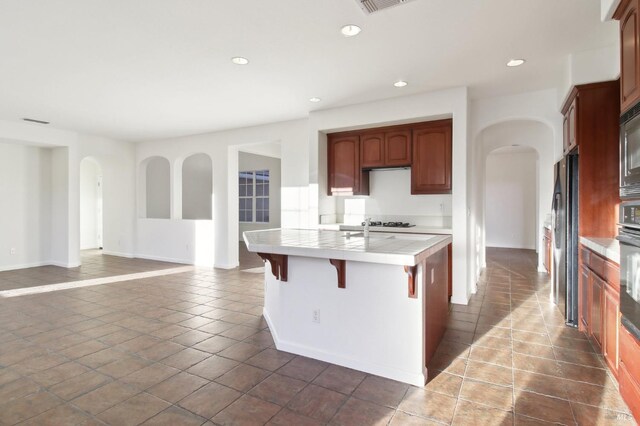 stairway with arched walkways, carpet floors, and baseboards