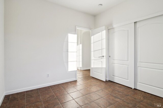 unfurnished room with carpet and baseboards