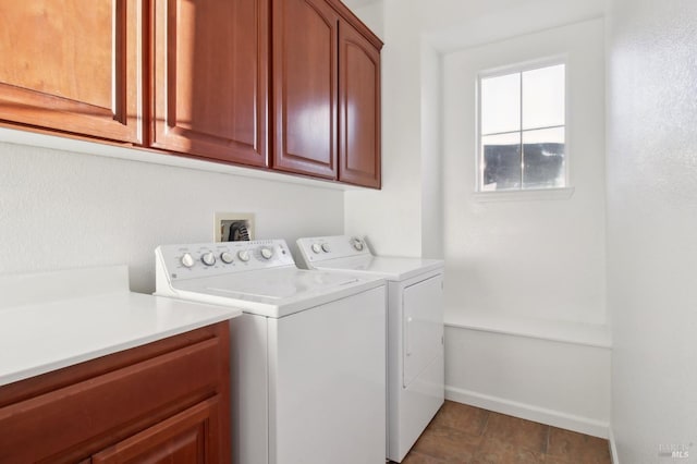 clothes washing area featuring washer and dryer and cabinets