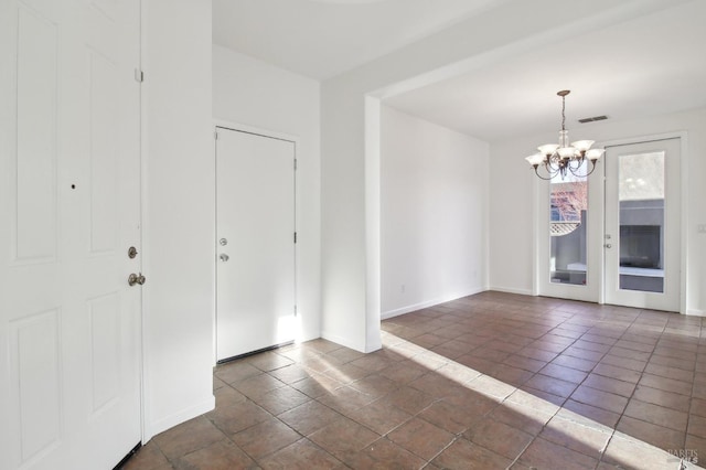 foyer featuring a notable chandelier and french doors