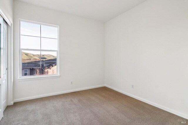 unfurnished bedroom featuring baseboards, a closet, and light colored carpet