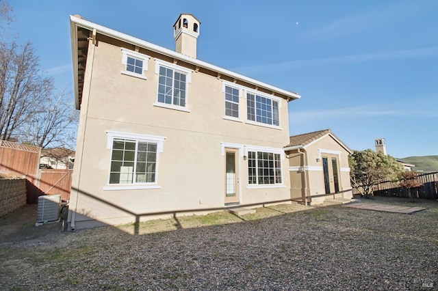 rear view of house featuring central AC