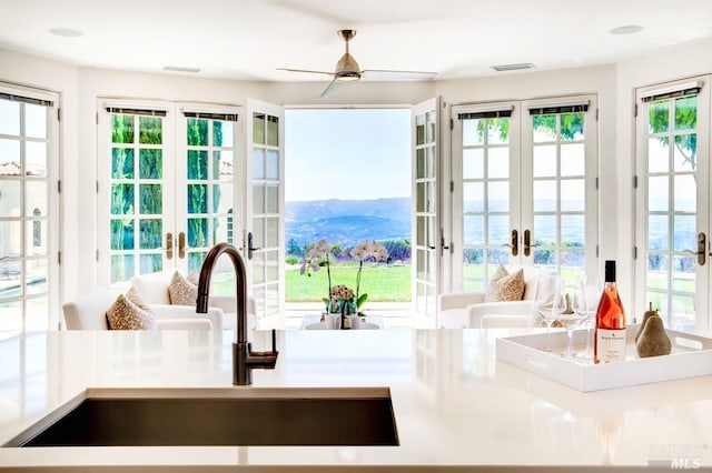 doorway featuring french doors, visible vents, a sink, and a water and mountain view