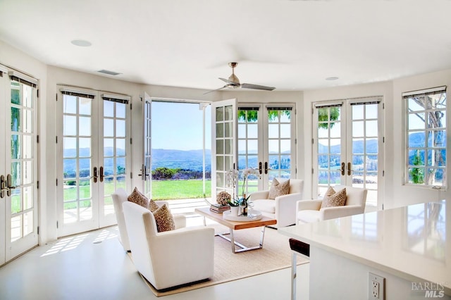 sunroom / solarium with french doors, a healthy amount of sunlight, a mountain view, and visible vents