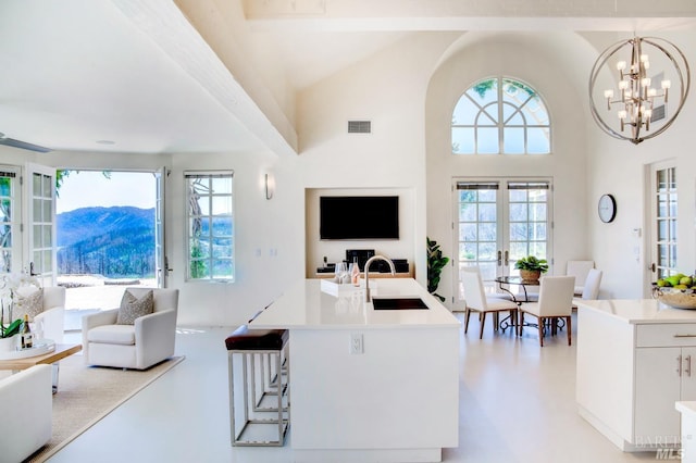 living room with high vaulted ceiling, french doors, and visible vents