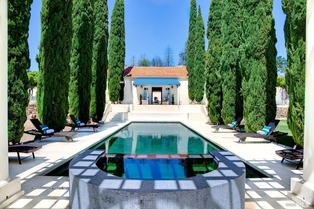 view of pool featuring a pool with connected hot tub and a patio area