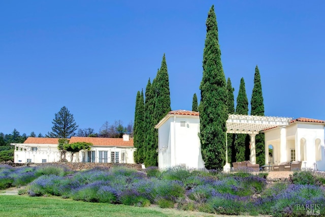 exterior space featuring a tile roof and a pergola