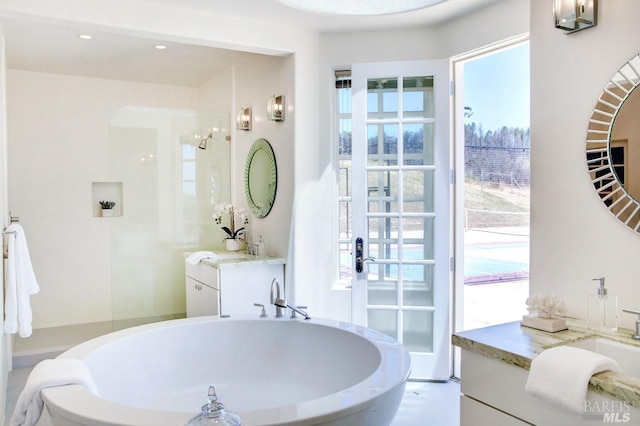 full bathroom featuring a freestanding tub, vanity, and recessed lighting