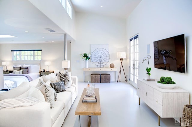 living area with visible vents, french doors, a towering ceiling, and recessed lighting