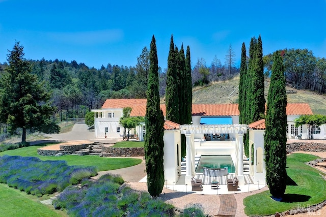 exterior space featuring a tiled roof, stairs, a patio area, a pergola, and stucco siding