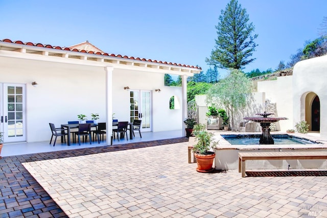 view of patio featuring fence, outdoor dining area, and french doors