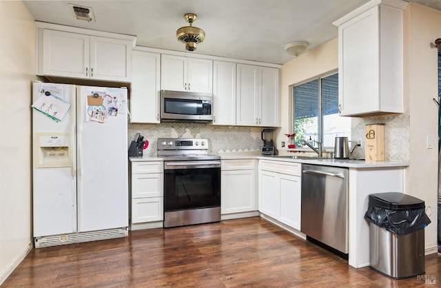 kitchen featuring stainless steel appliances, tasteful backsplash, dark hardwood / wood-style floors, and white cabinets