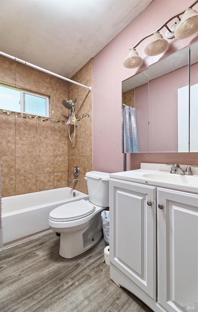 full bathroom featuring vanity, hardwood / wood-style flooring, toilet, and shower / bathtub combination with curtain