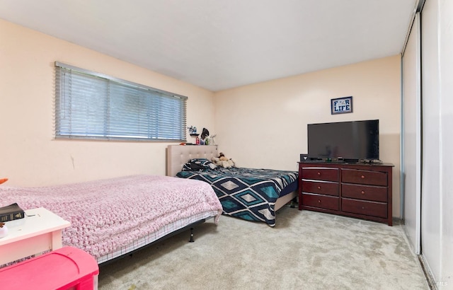 bedroom with light carpet and a closet