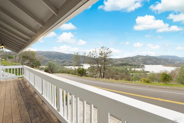 balcony featuring a water and mountain view