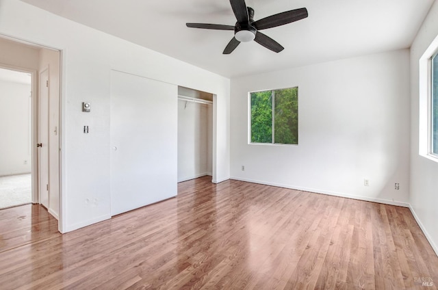 unfurnished bedroom with ceiling fan, a closet, and wood finished floors