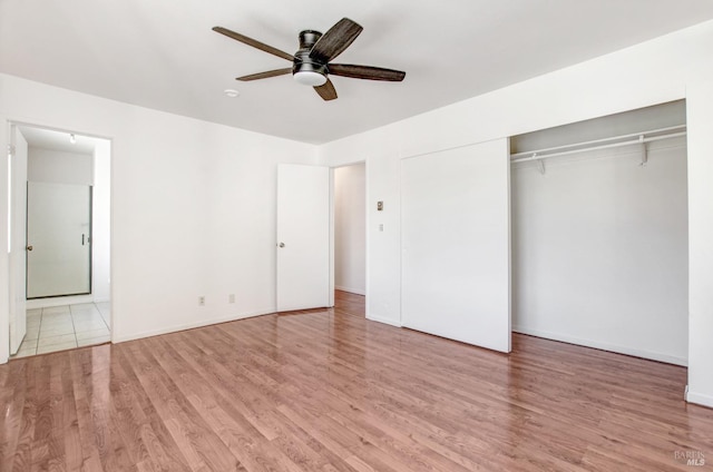 unfurnished bedroom featuring ceiling fan, a closet, baseboards, and wood finished floors