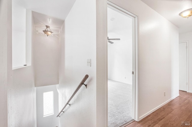 staircase with baseboards and wood finished floors