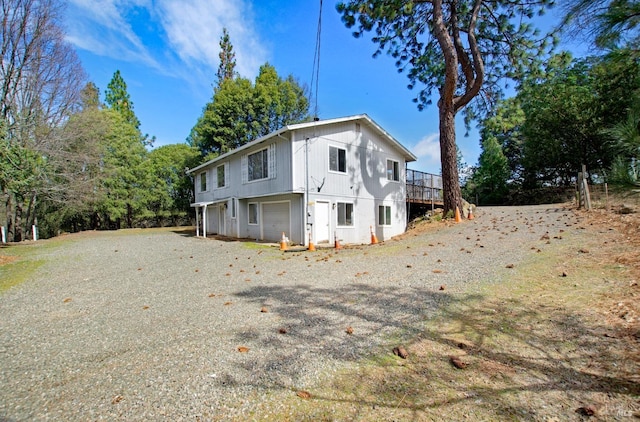 back of house featuring a garage and driveway