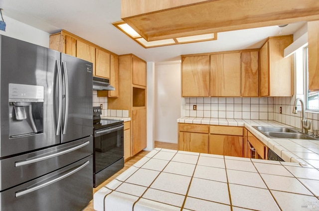 kitchen featuring under cabinet range hood, electric range, a sink, tile counters, and stainless steel fridge with ice dispenser