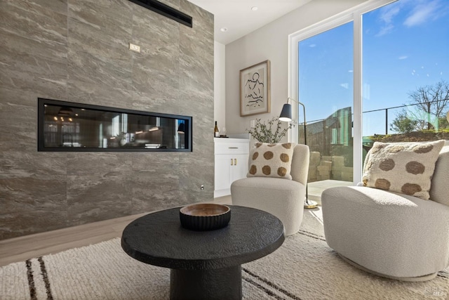 living area featuring a large fireplace and hardwood / wood-style floors