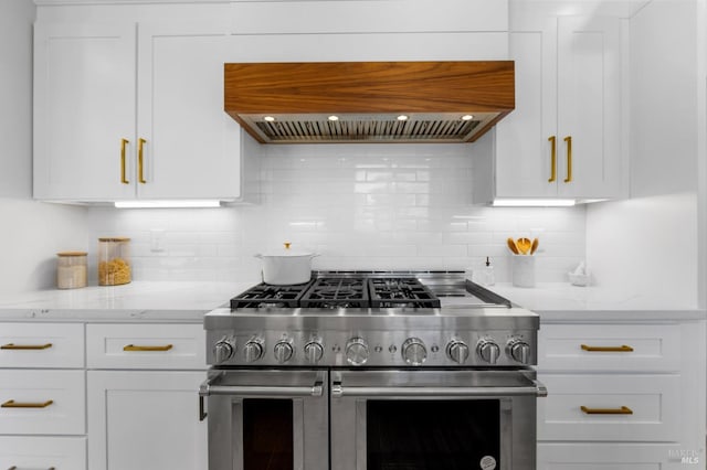 kitchen with white cabinetry, backsplash, custom exhaust hood, and range with two ovens