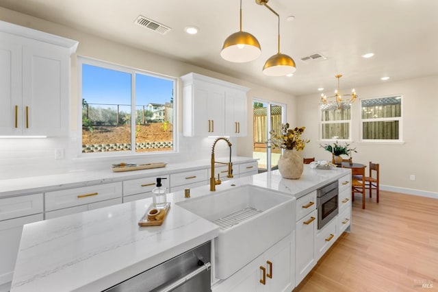 kitchen with white cabinets, decorative light fixtures, and backsplash