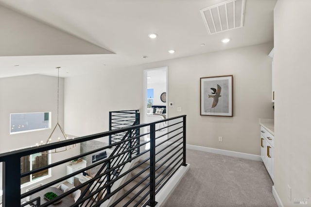 hall featuring a notable chandelier and light colored carpet