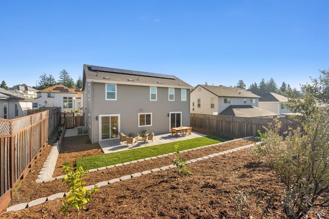 rear view of house featuring solar panels, an outdoor fire pit, and a patio area