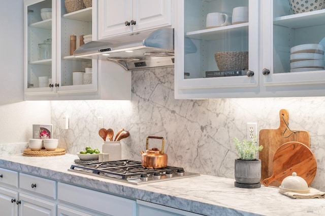 kitchen with white cabinetry, backsplash, and stainless steel gas stovetop