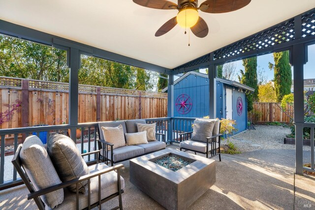 view of patio / terrace with ceiling fan, a storage unit, and an outdoor living space with a fire pit