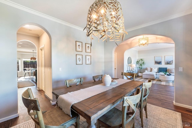 dining area with an inviting chandelier, ornamental molding, and dark hardwood / wood-style floors