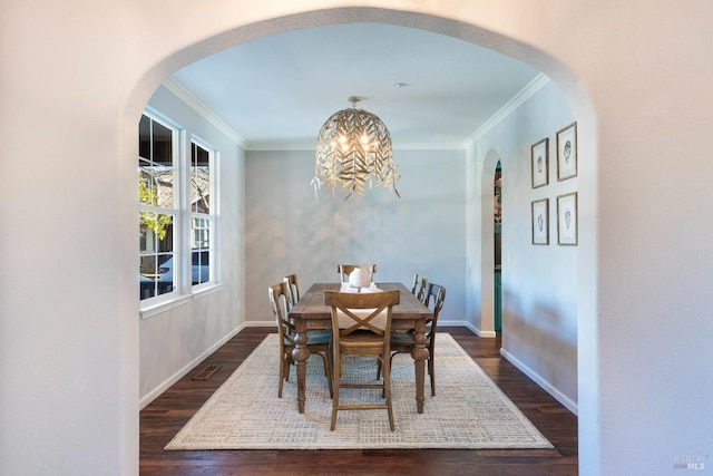 dining space featuring ornamental molding, dark hardwood / wood-style floors, and a chandelier