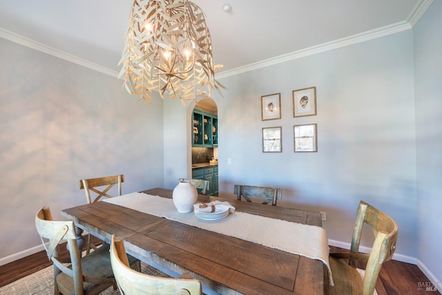 dining room featuring ornamental molding, hardwood / wood-style floors, and a notable chandelier