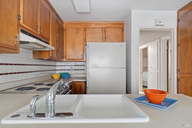 kitchen with white appliances, tasteful backsplash, and sink