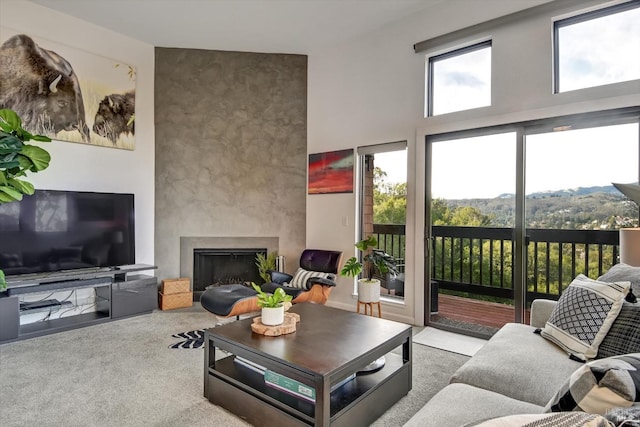 living room featuring a large fireplace and carpet