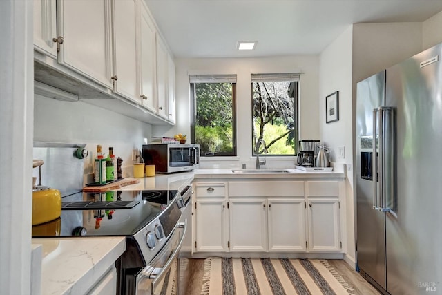 kitchen with sink, white cabinets, and stainless steel appliances