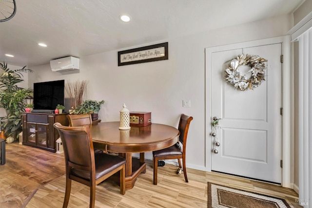 dining room featuring a wall unit AC and light hardwood / wood-style flooring