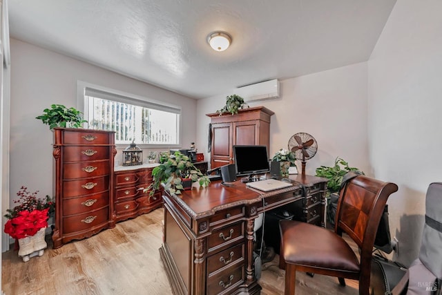 home office featuring light hardwood / wood-style flooring and an AC wall unit