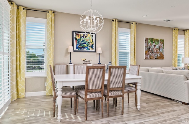 dining area featuring light hardwood / wood-style flooring and a notable chandelier