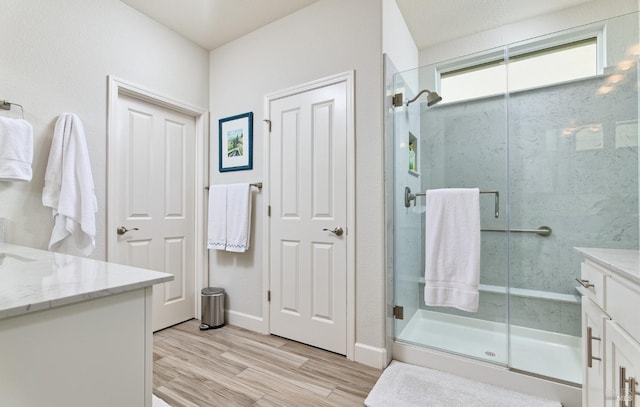 bathroom featuring vanity, wood-type flooring, and walk in shower