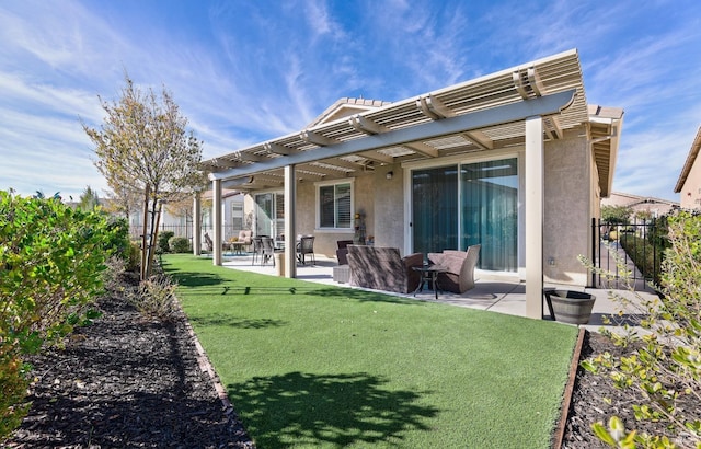 back of property with a pergola, a patio area, and a lawn