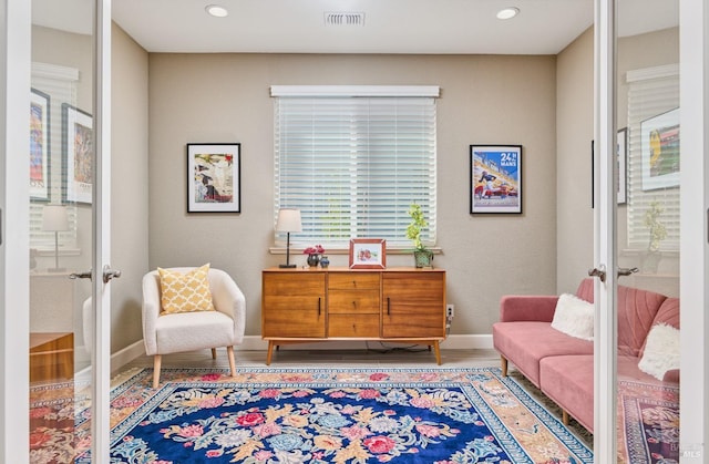 living area with french doors and hardwood / wood-style floors