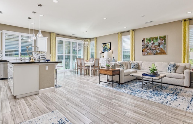 living room with a chandelier and light hardwood / wood-style floors