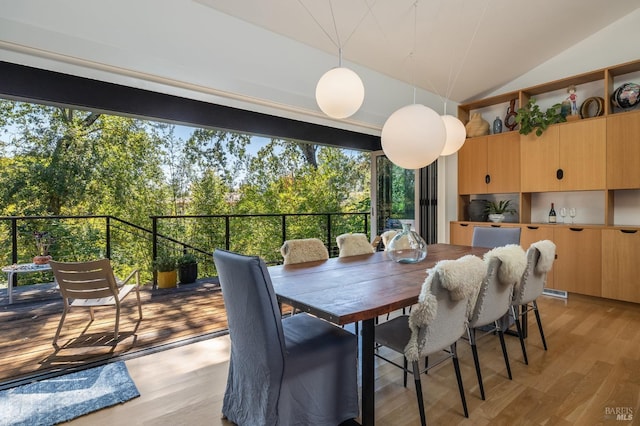 dining area featuring vaulted ceiling and light wood-type flooring