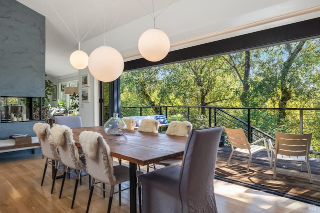 dining space with light wood-type flooring and lofted ceiling