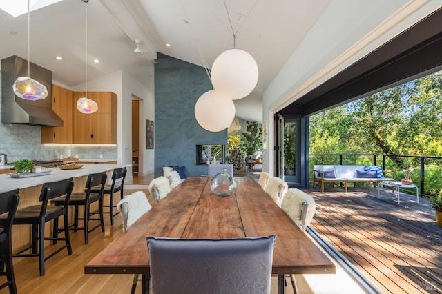 dining space featuring light hardwood / wood-style floors and lofted ceiling