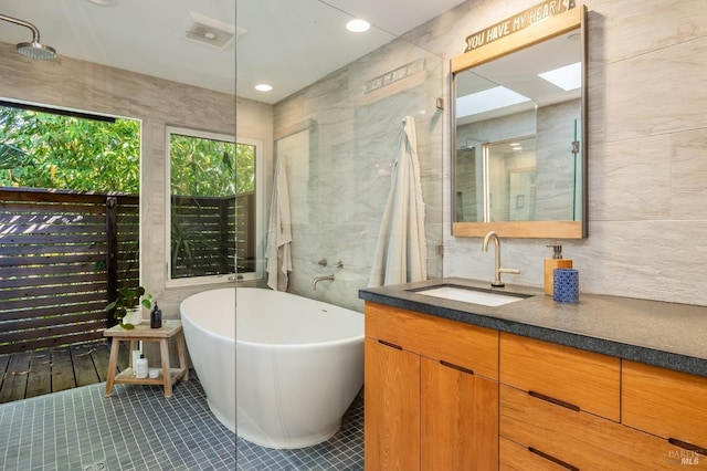 bathroom with tile patterned floors, vanity, and tile walls