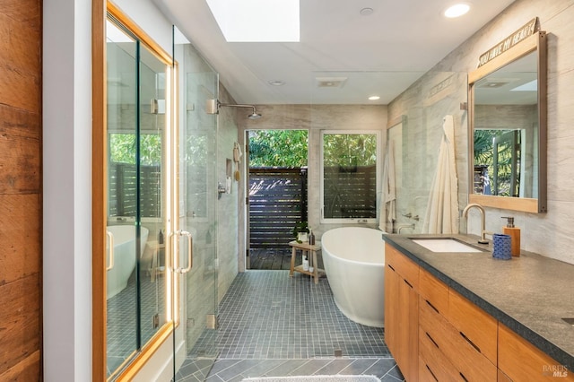 bathroom featuring a skylight, a wealth of natural light, tile patterned flooring, and independent shower and bath