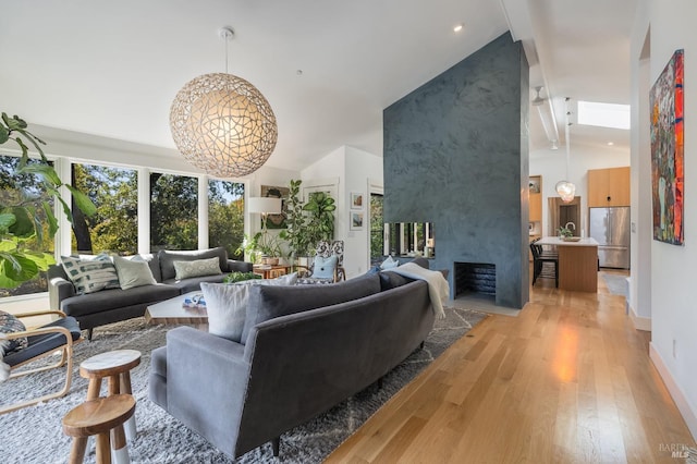 living room with light hardwood / wood-style floors, a fireplace, and high vaulted ceiling